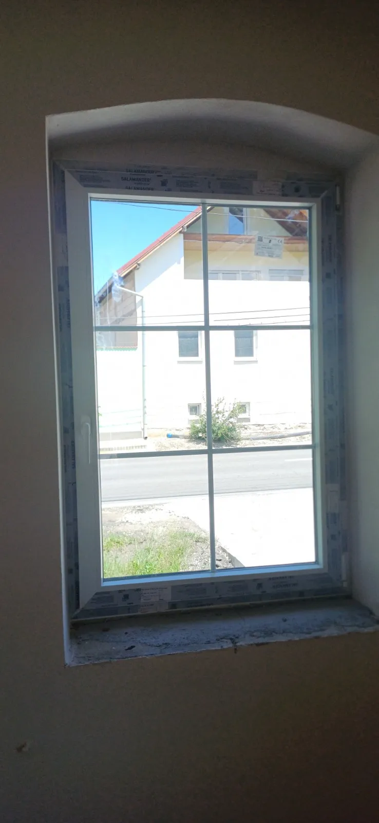 Fereastră arcuită cu vedere spre o stradă rezidențială