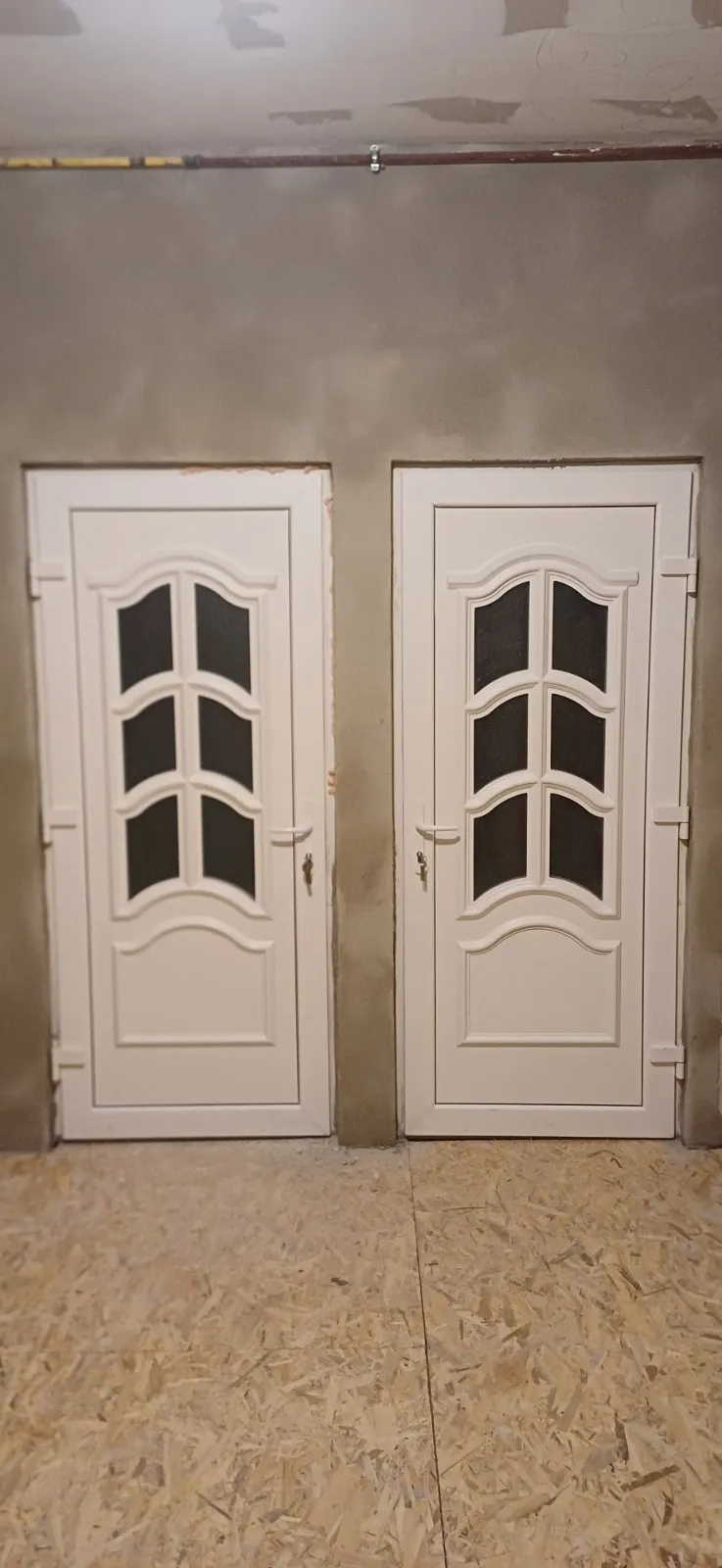 Ușă dublă albă cu geam decorativ, văzută din interior