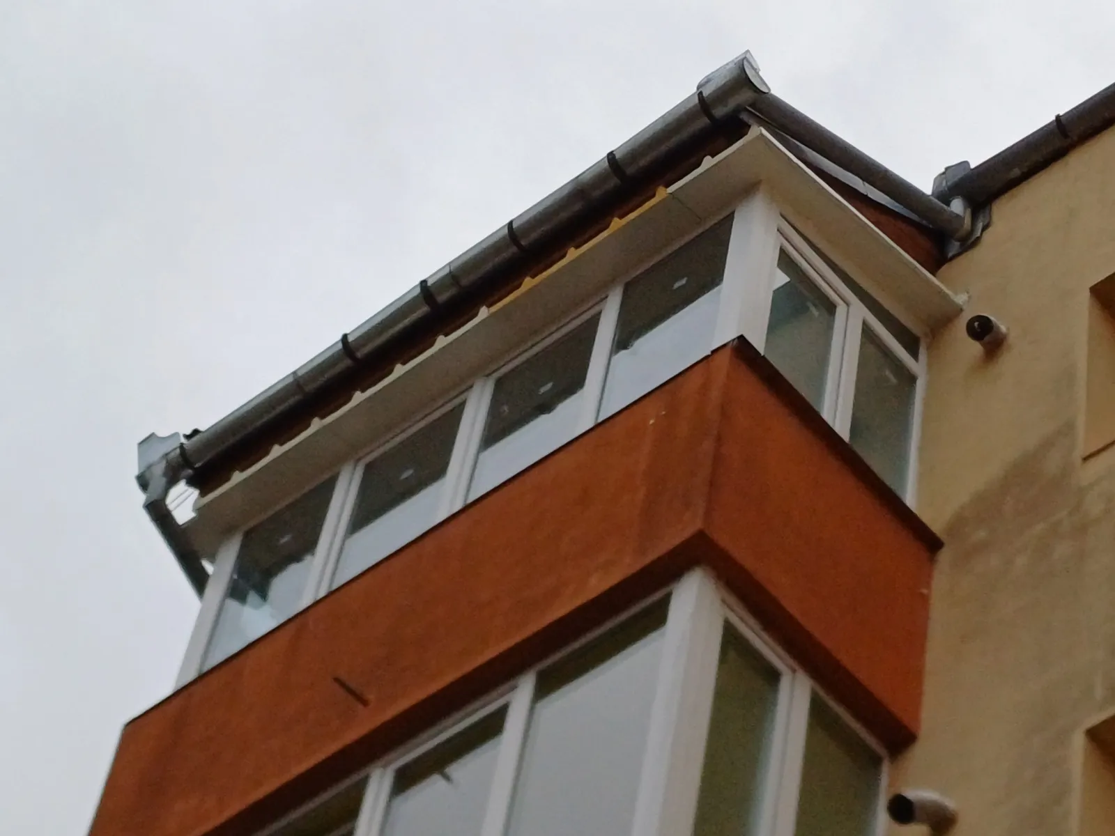 Balcon închis la o casă cu fațadă portocalie